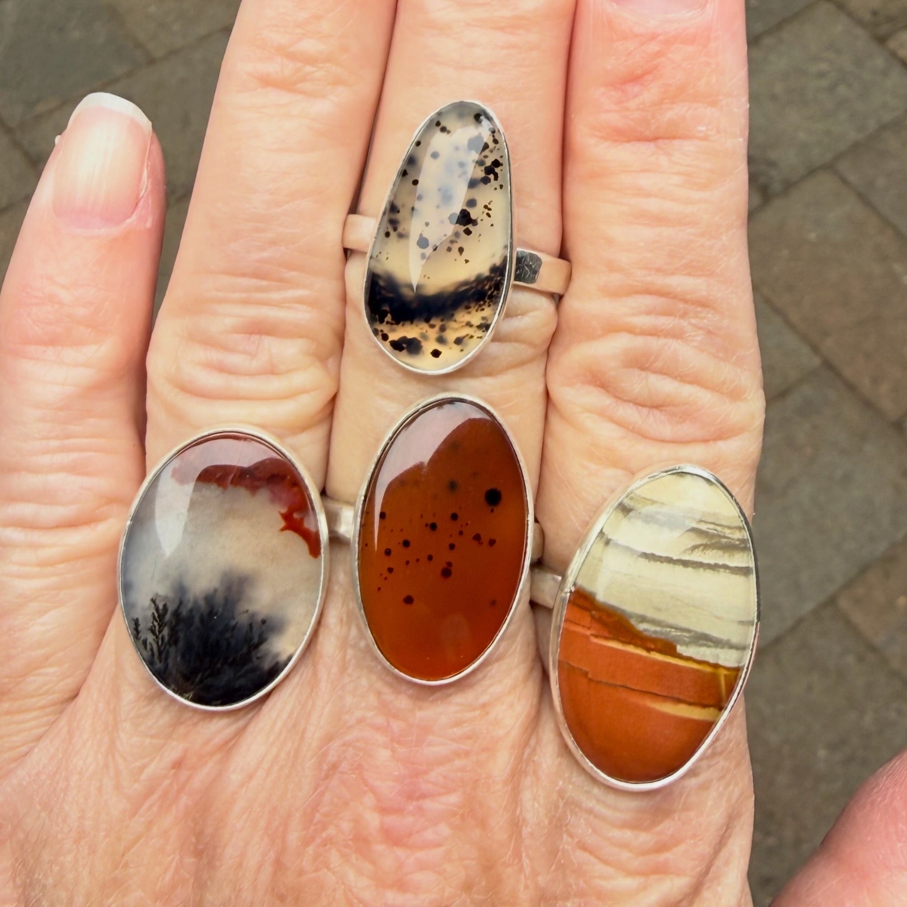 Three Agate rings on a hand with a neutral background