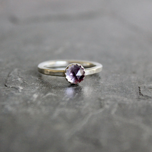 Silver ring with a lab-created alexandrite on a gray surface