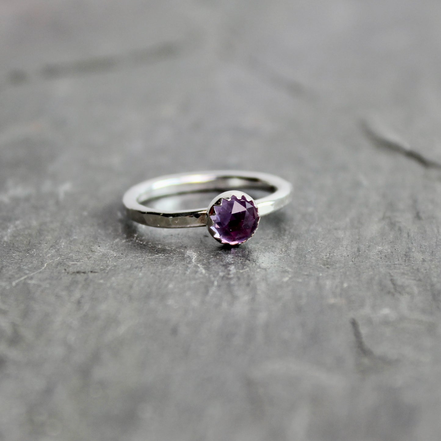 Silver ring with a lab-created alexandrite on a gray surface
