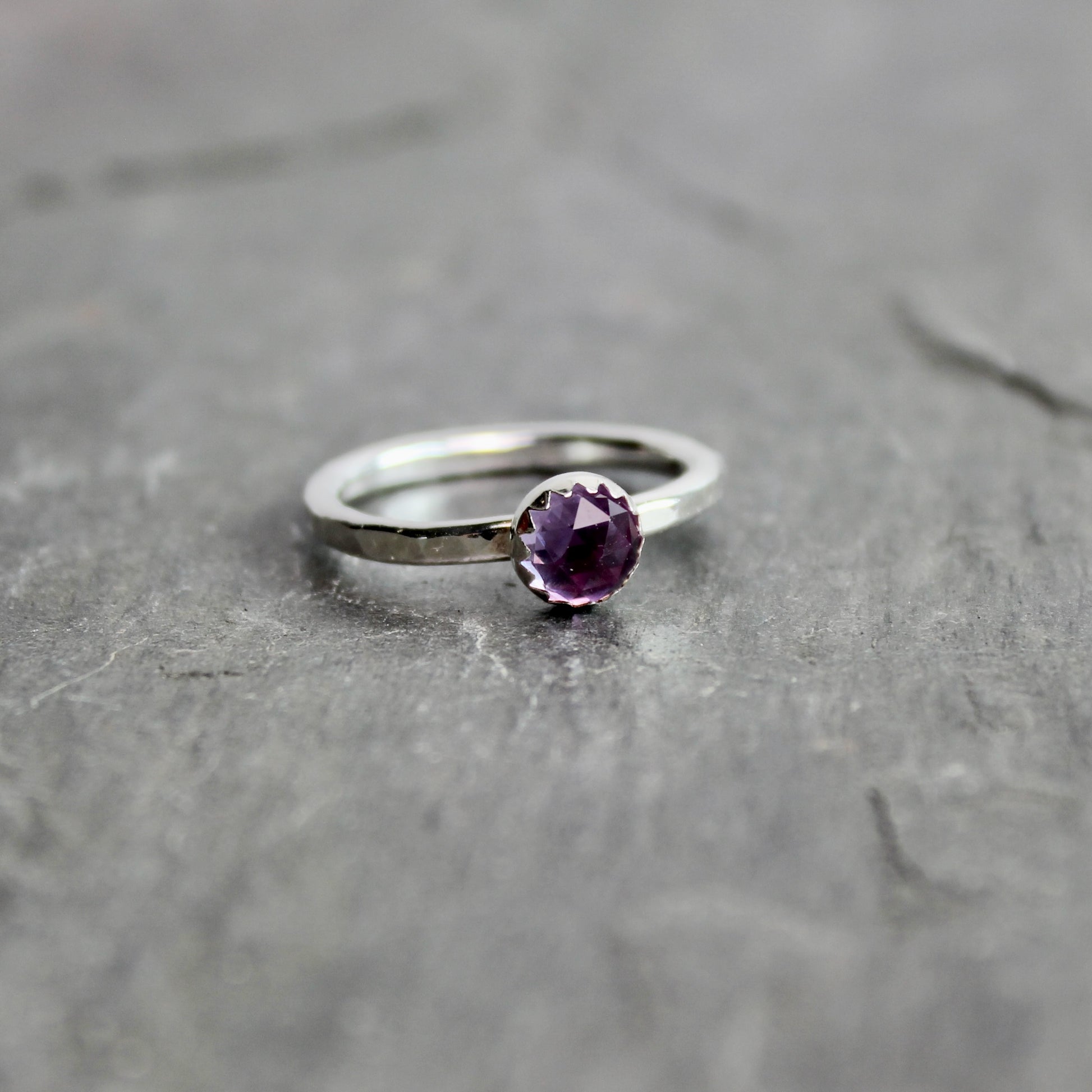 Silver ring with a lab-created alexandrite on a gray surface