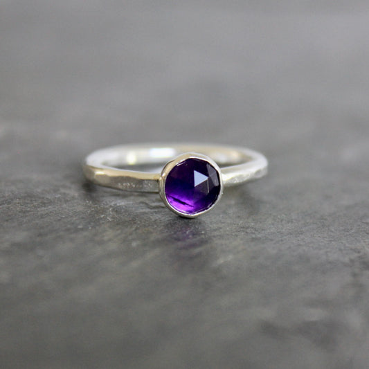Silver ring with a purple amethyst  gemstone on a gray background