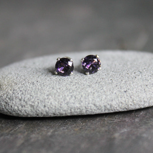 These stud earrings have 4mm round faceted lab created amethysts set in 4-prong sterling silver stud earring settings with ear nuts. 