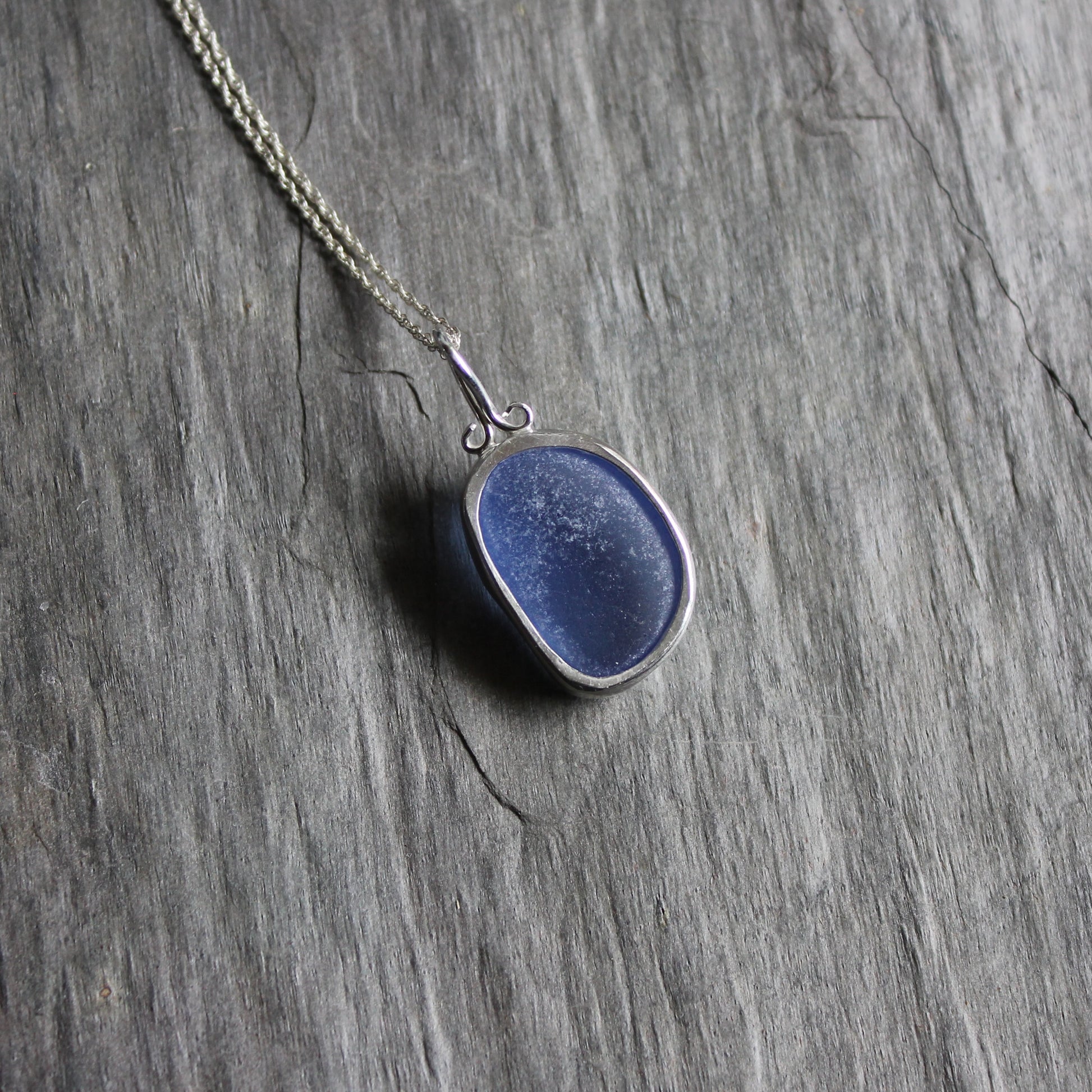 This necklace has a large chunky piece of cornflower blue sea glass set in a fine & sterling silver bezel setting on a sterling silver chain. 