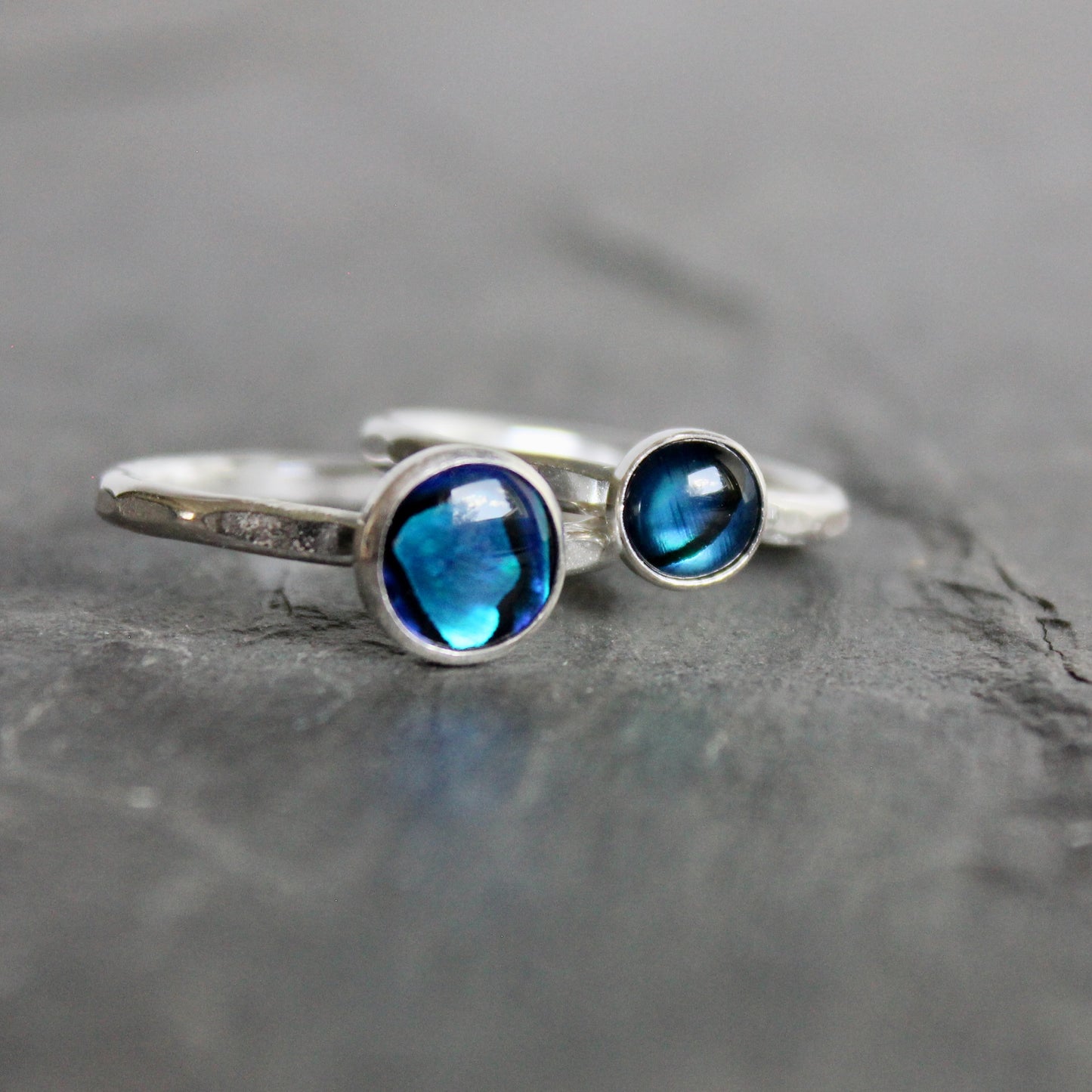 2 Silver ring with blue gemstones on a gray stone surface