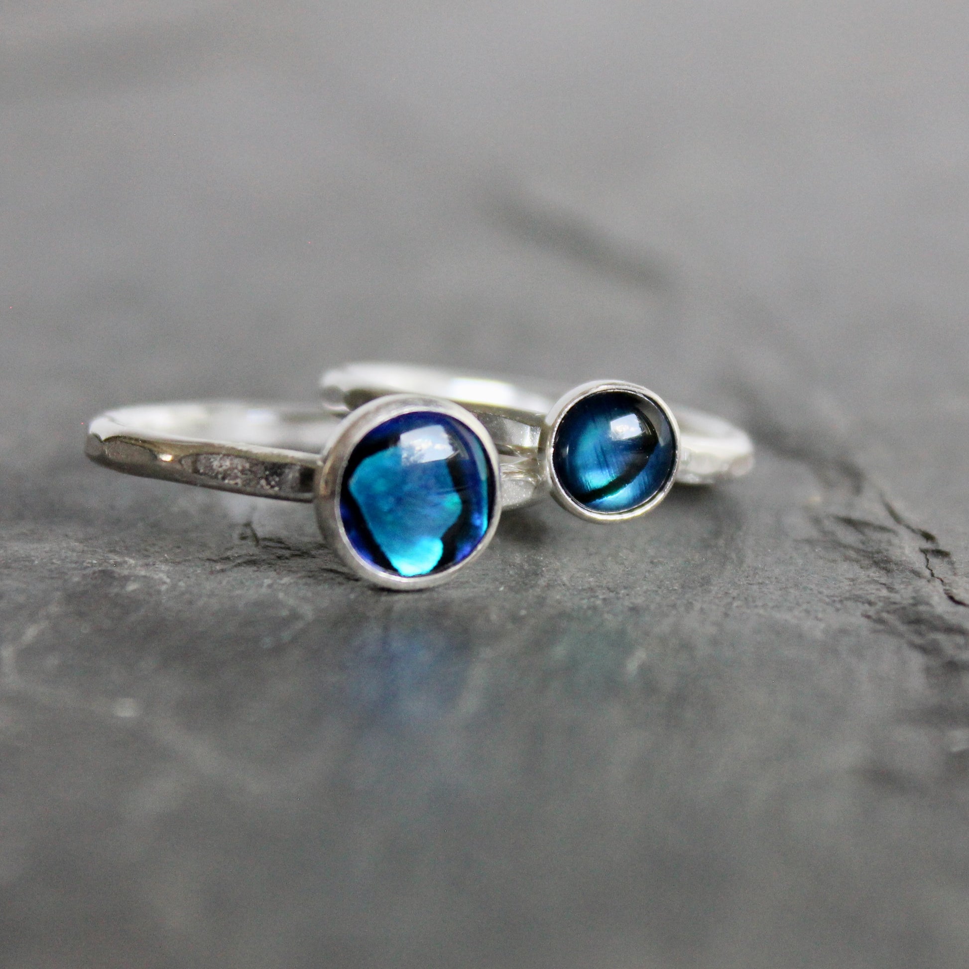 2 Silver ring with blue gemstones on a gray stone surface