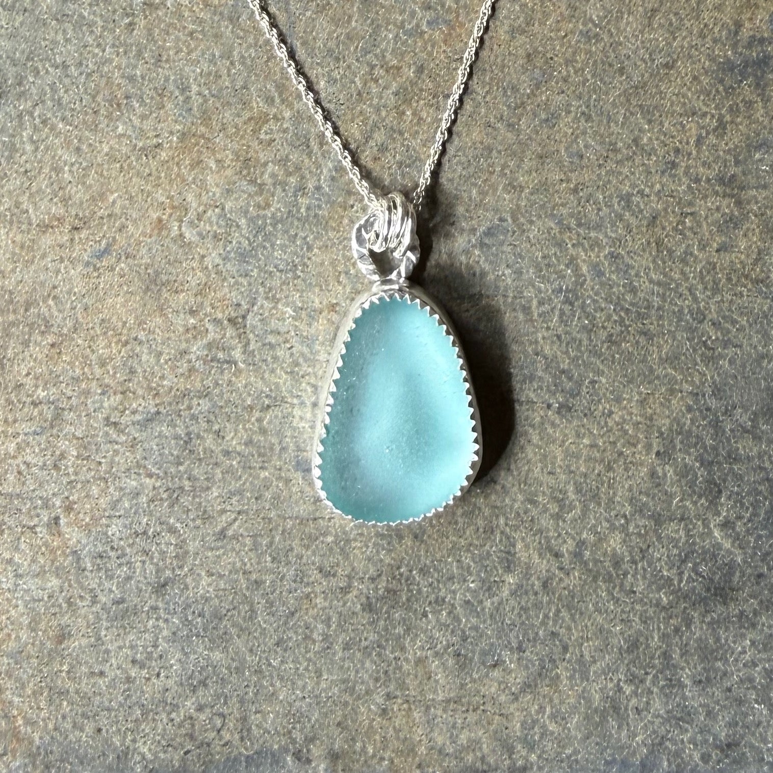 Aqua Sea Glass Necklace on a stone surface