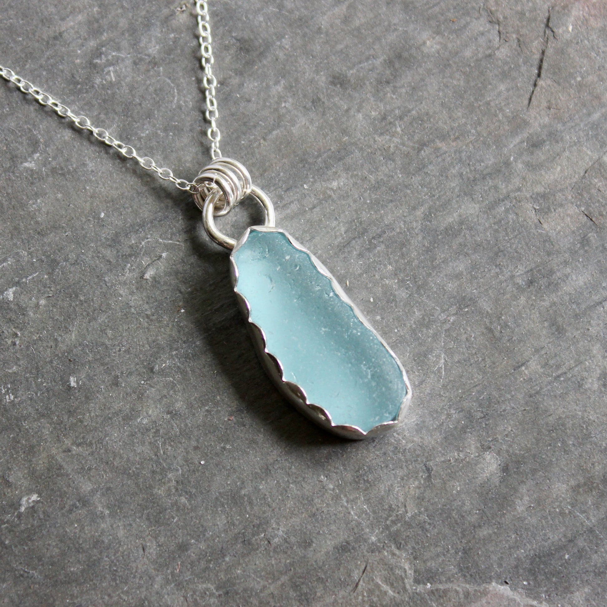 Necklace with a turquoise sea glass on a gray background