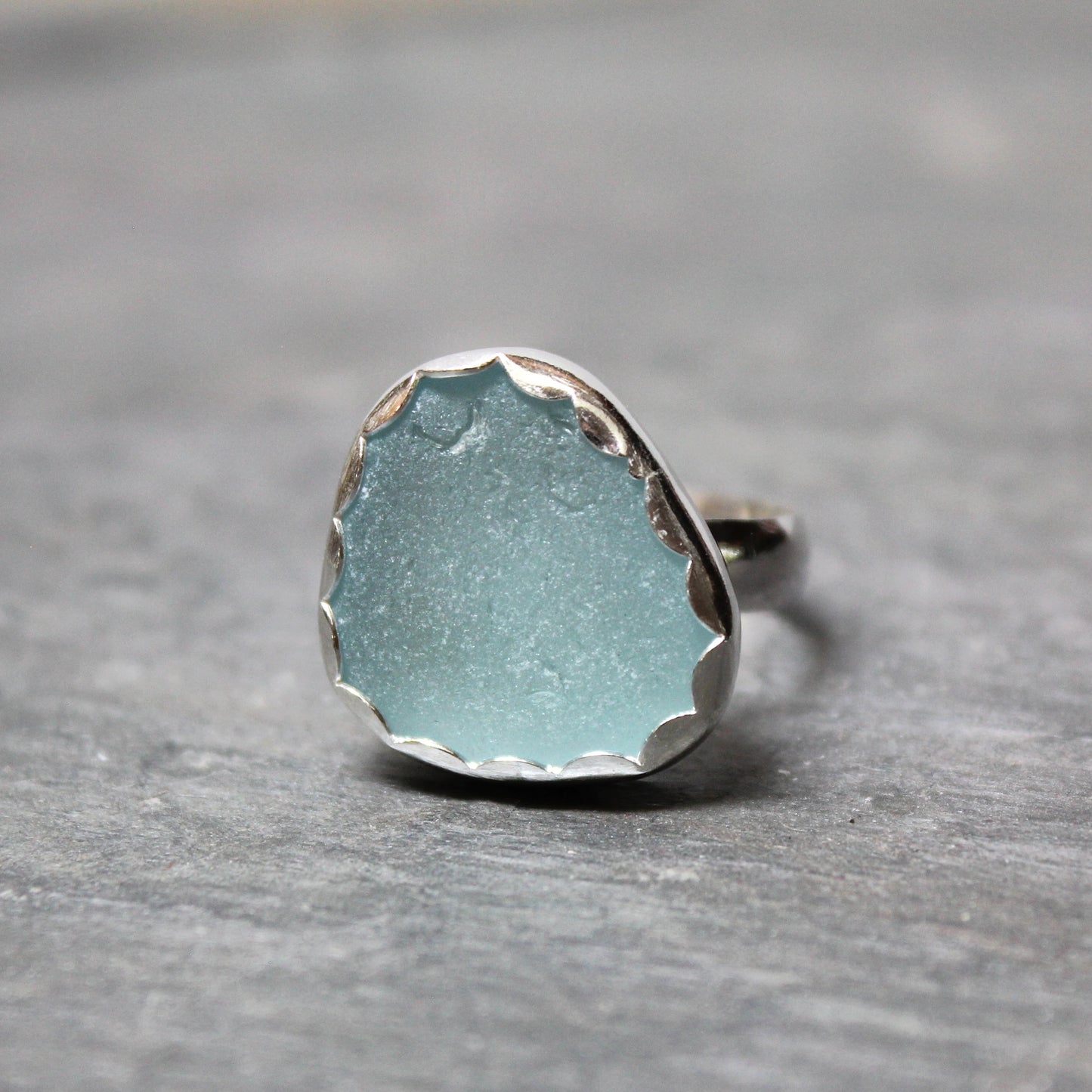 Ring with a light blue Sea Glass on a gray surface