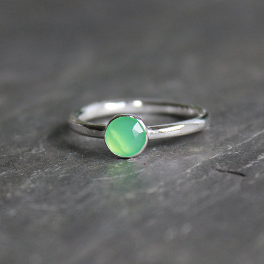 Silver ring with a green chrysoprase gemstone on a dark surface