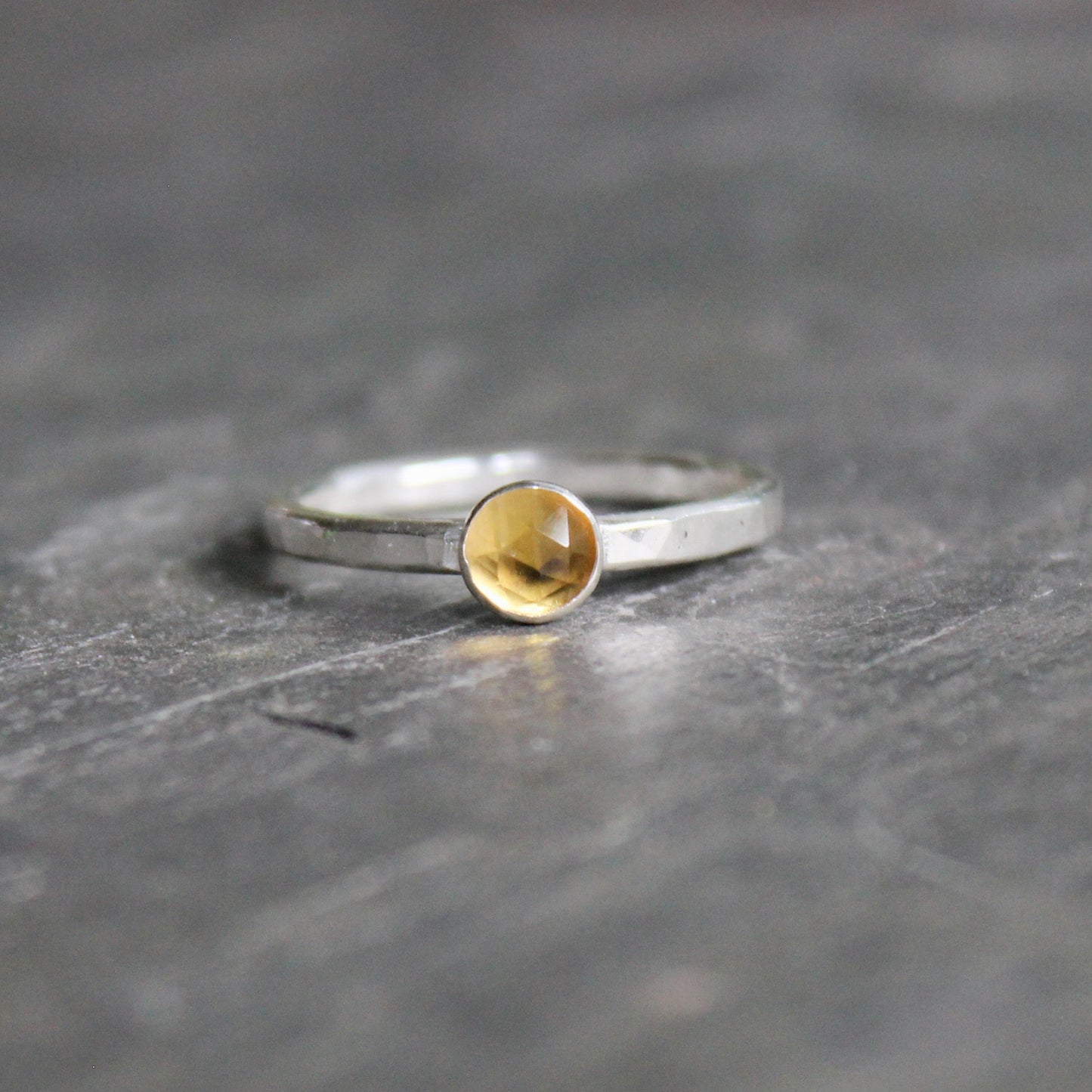 Silver ring with a gold accent on a dark stone surface