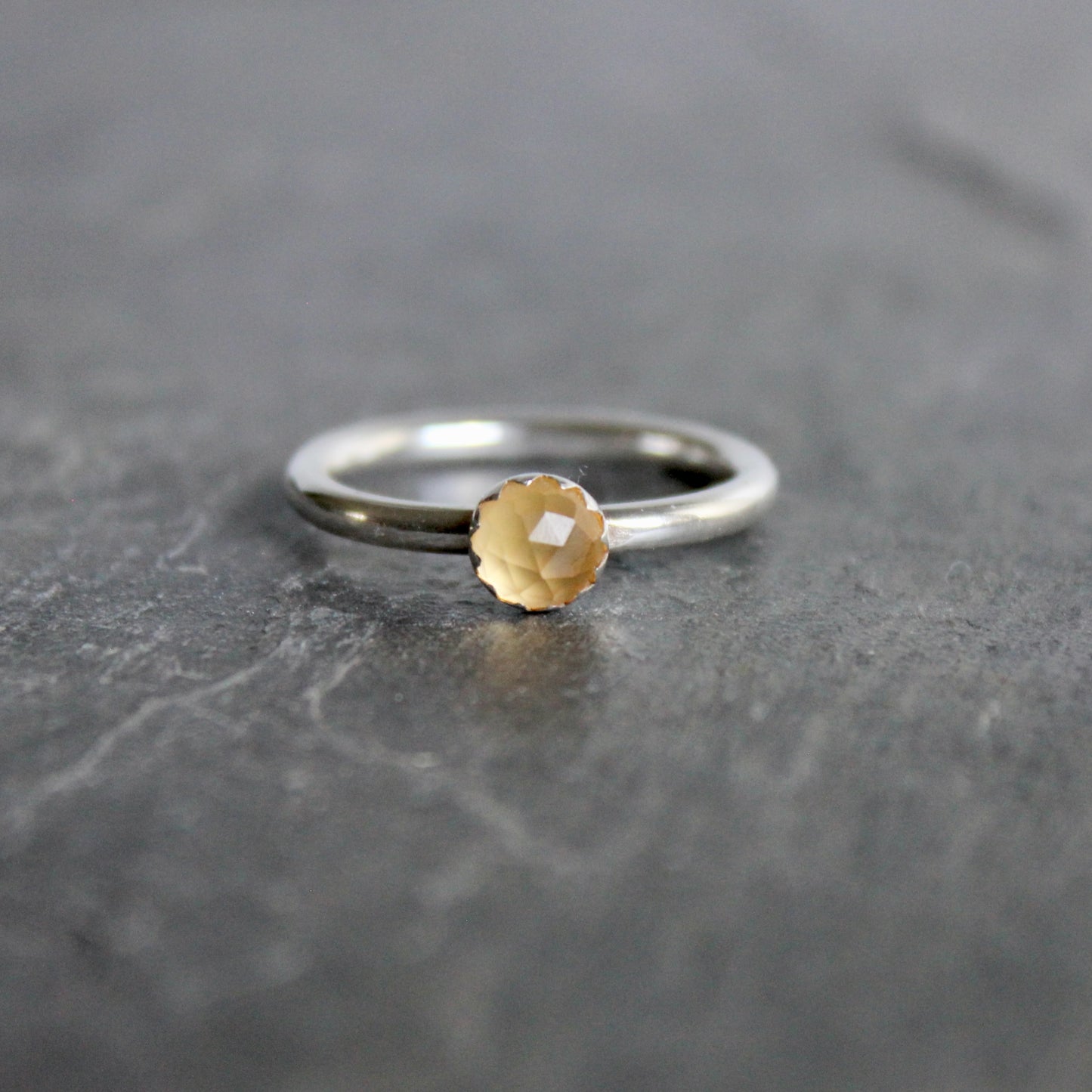Silver ring with a rose cut citrine on a dark gray surface
