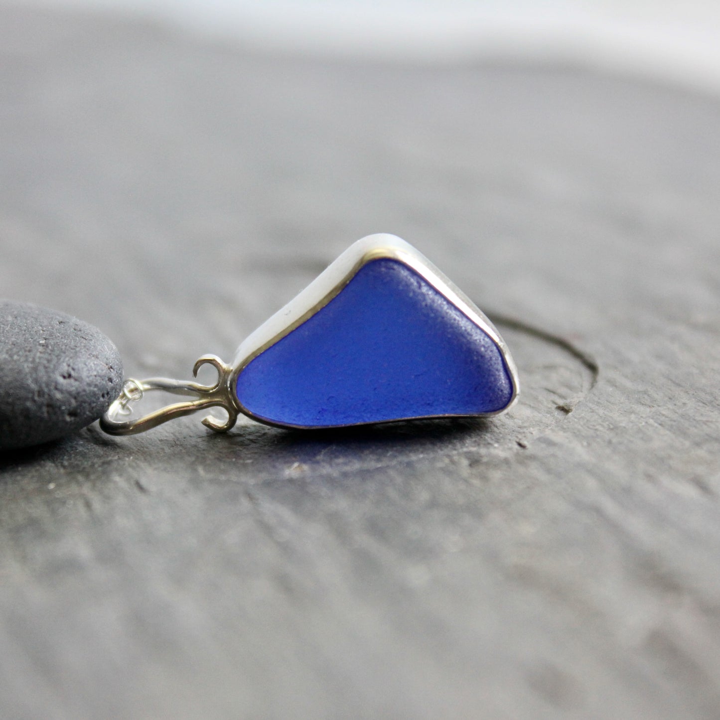  Cobalt blue sea glass pendant on a gray surface