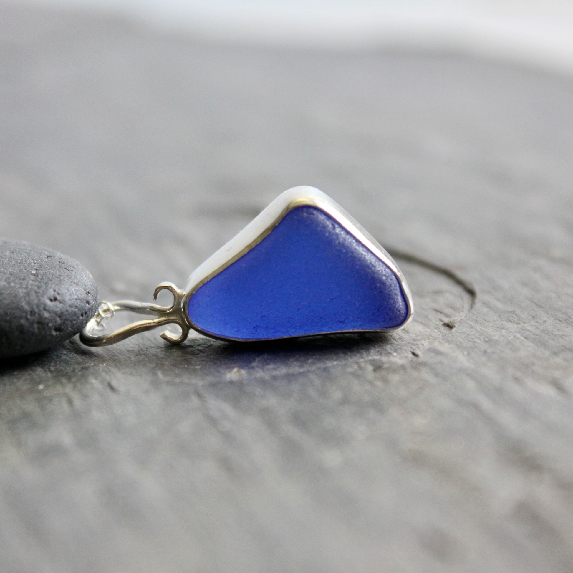  Cobalt blue sea glass pendant on a gray surface