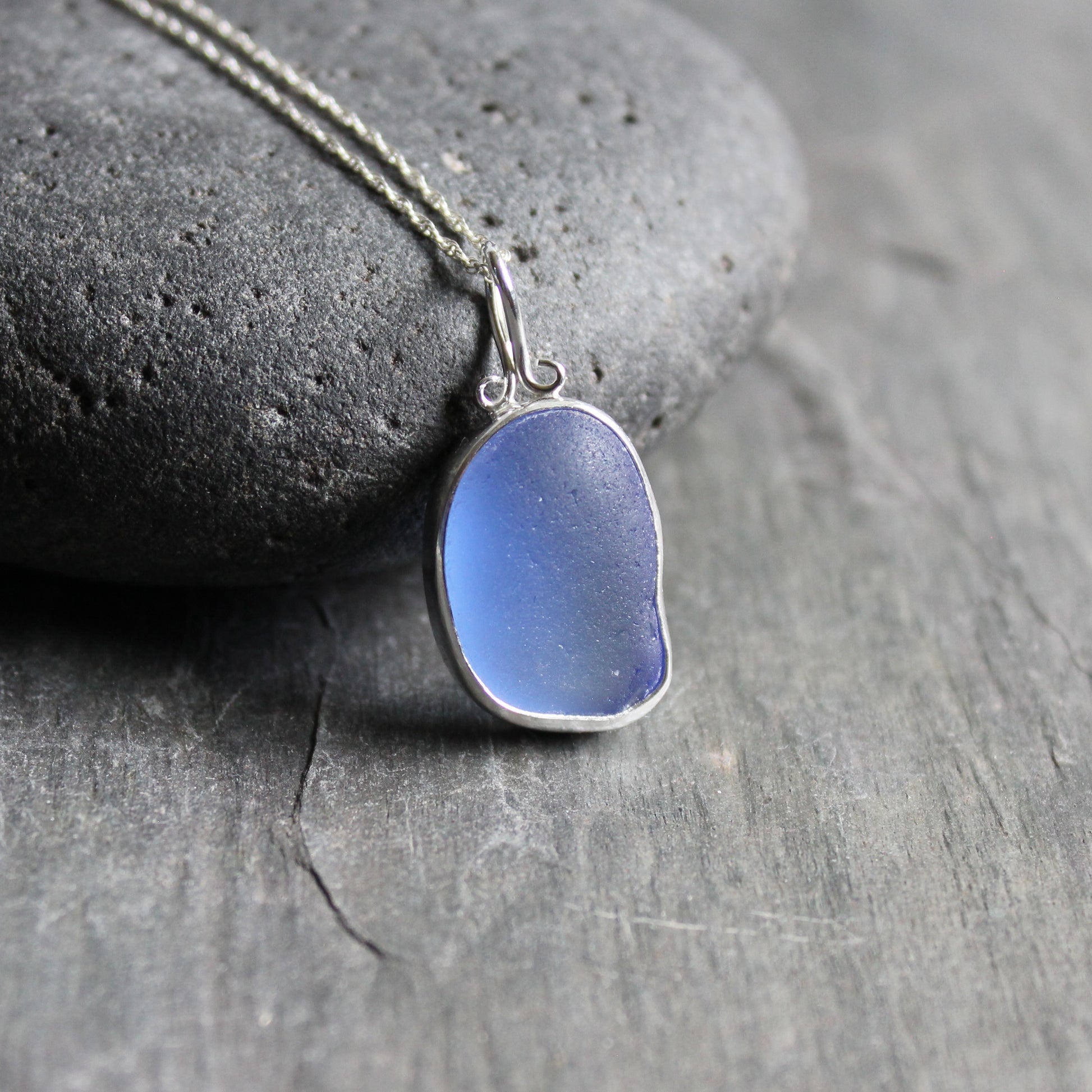 This necklace has a large chunky piece of cornflower blue sea glass set in a fine & sterling silver bezel setting on a sterling silver chain. 