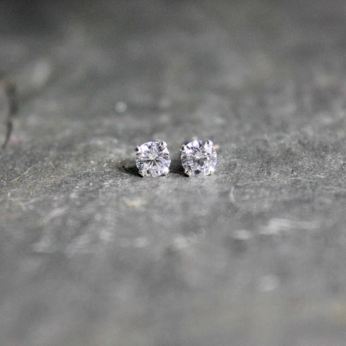 These stud earrings have 4mm round faceted cubic zirconia gemstones set in sterling silver 4-prong earring settings with earring backs.