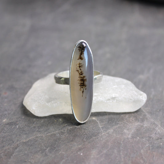 Silver ring with a natural stone on a gray surface