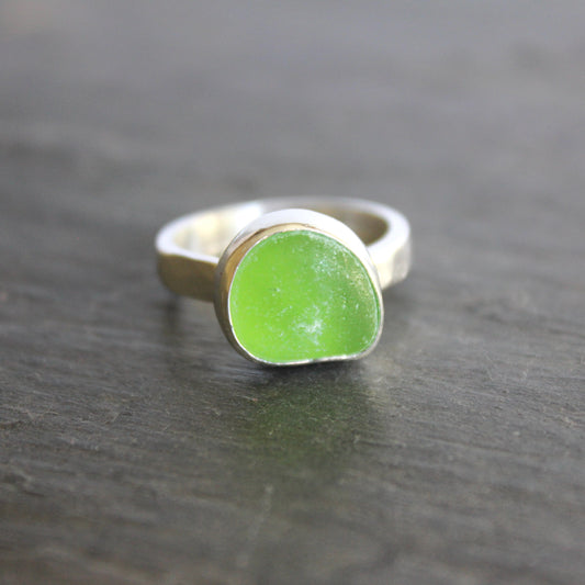 A ring made with a bright green piece of sea glass set in sterling silver. Size 8.5