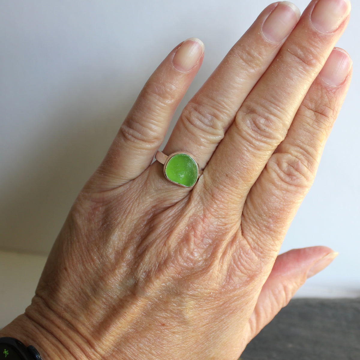 A ring made with a bright green piece of sea glass set in sterling silver. Size 8.5