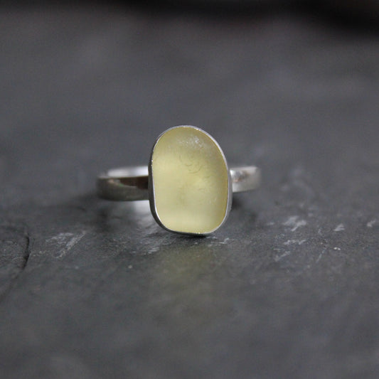 This is a pale yellow piece of sea glass set in a fine & sterling silver bezel setting on a sturdy silver band. 