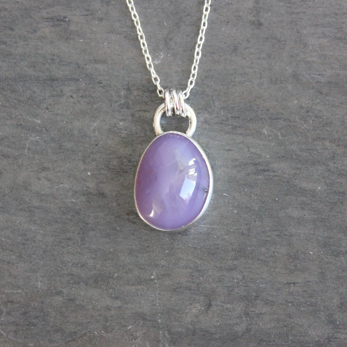 Purple holley blue agate pendant necklace on a dark gray background