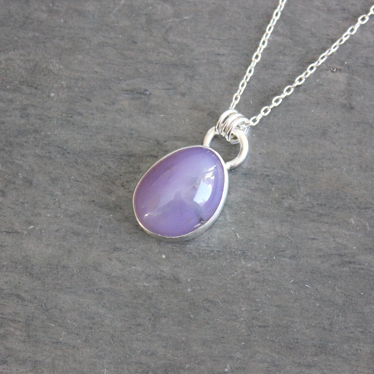 Purple holley blue agate pendant necklace on a dark gray background