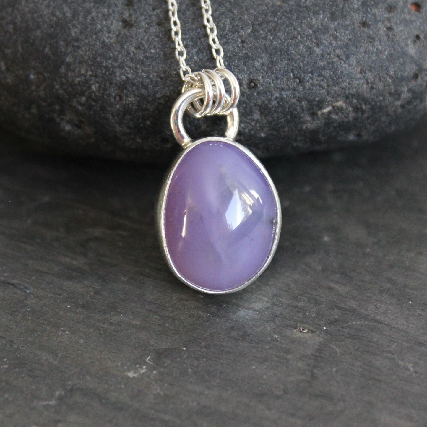 Purple holley blue agate pendant necklace on a dark gray background
