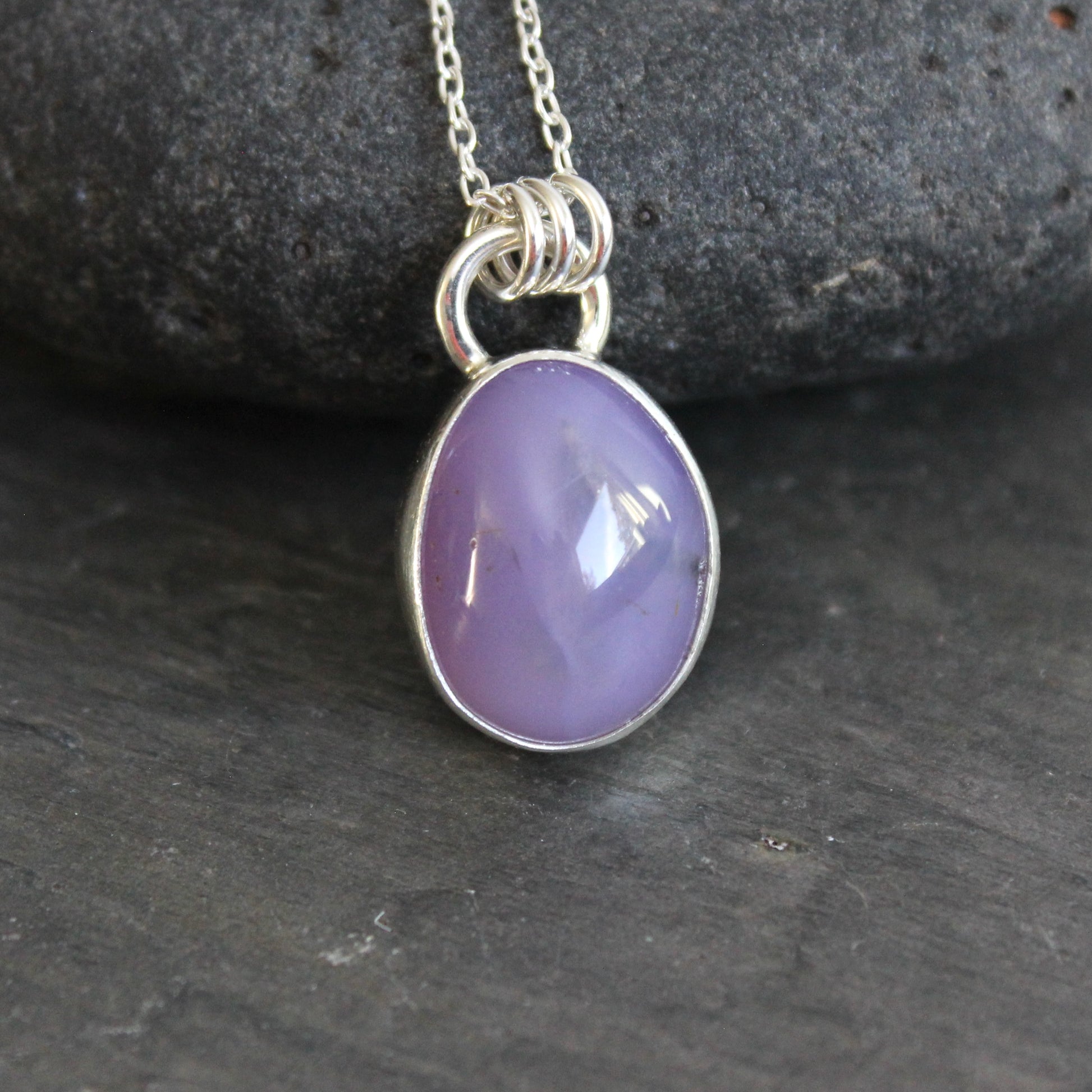 Purple holley blue agate pendant necklace on a dark gray background