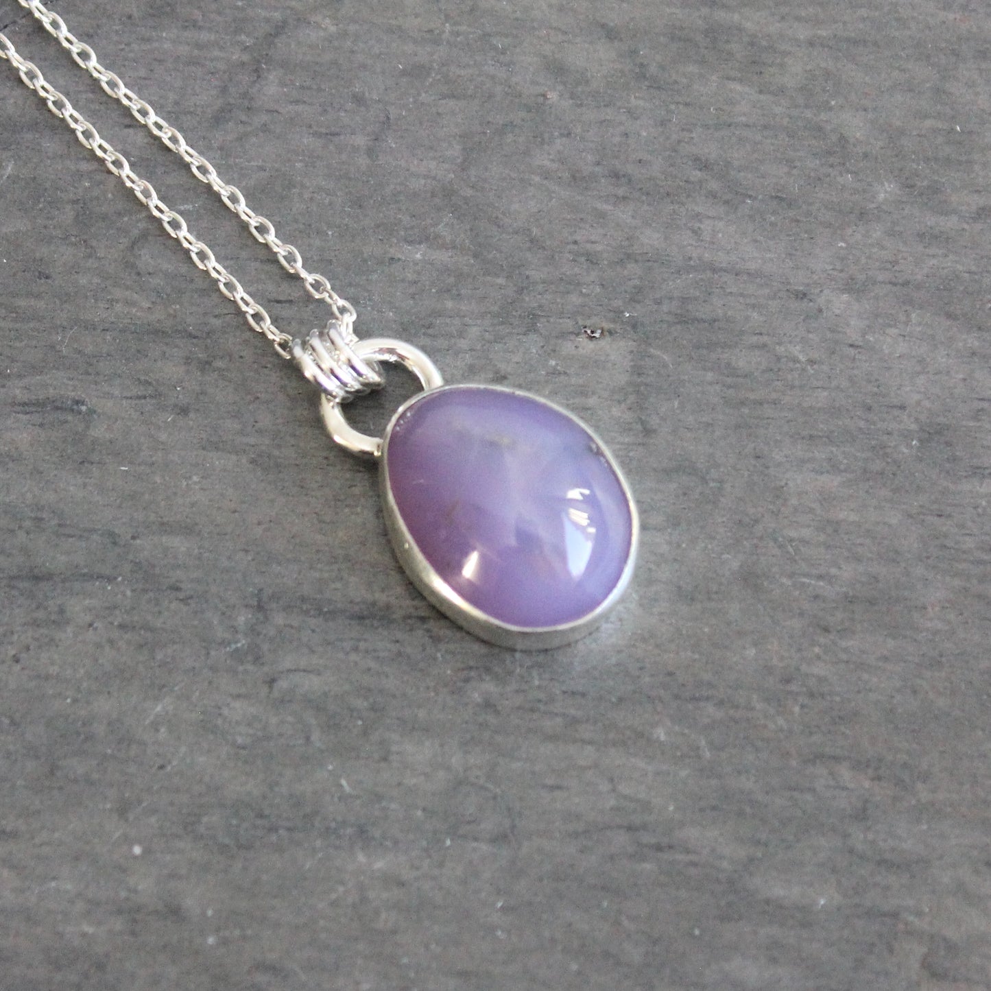 Purple holley blue agate pendant necklace on a dark gray background