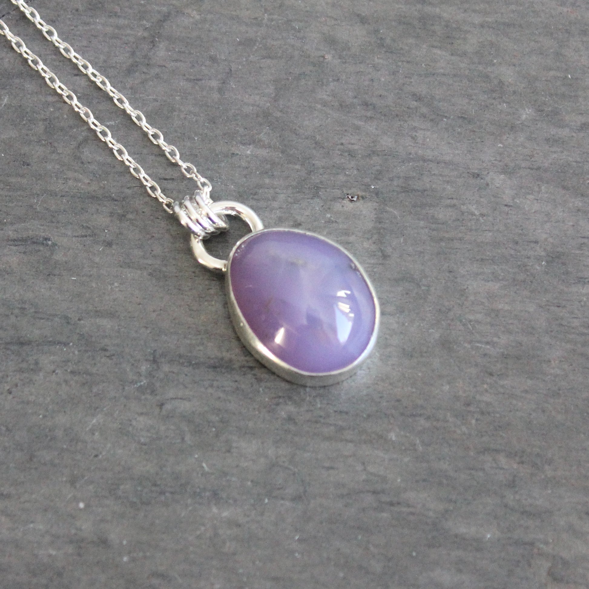 Purple holley blue agate pendant necklace on a dark gray background