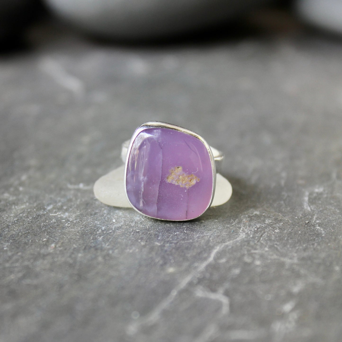 Silver ring with a holley blue agate on a gray surface