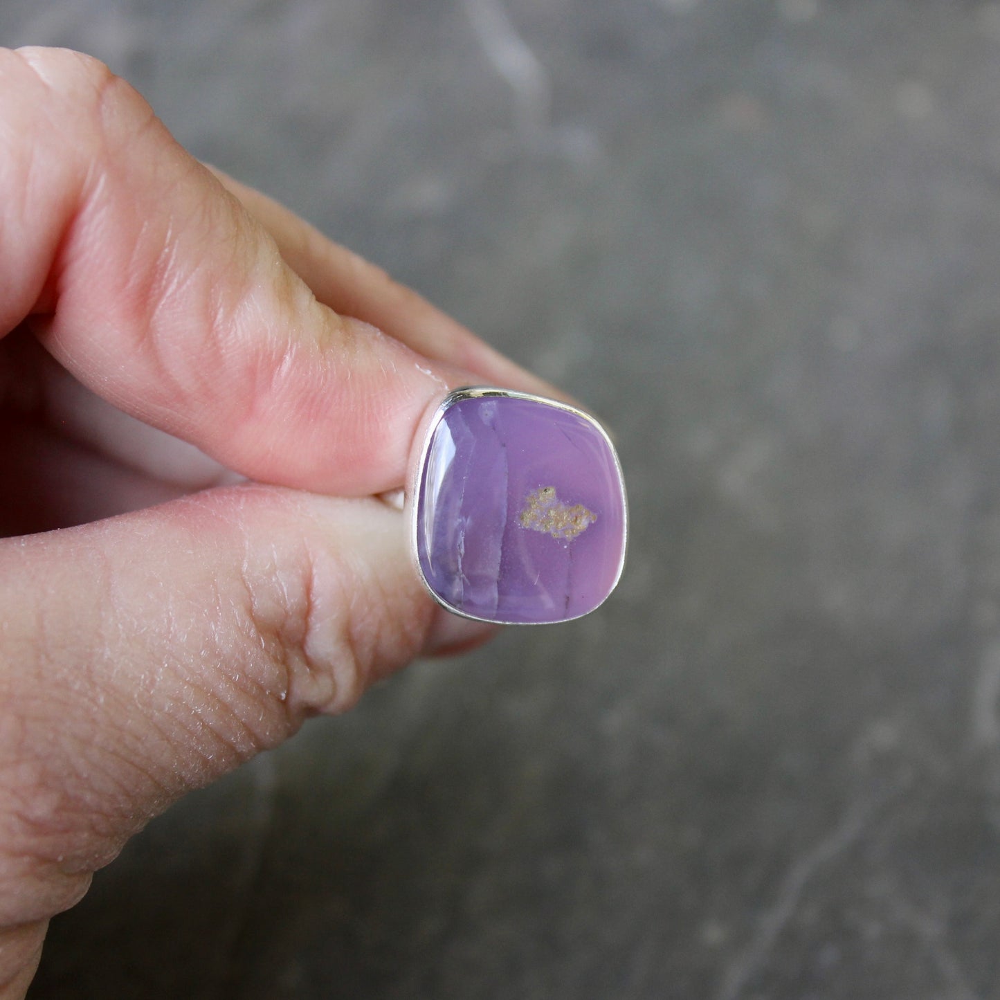 Hand holding a holley blue agate ring