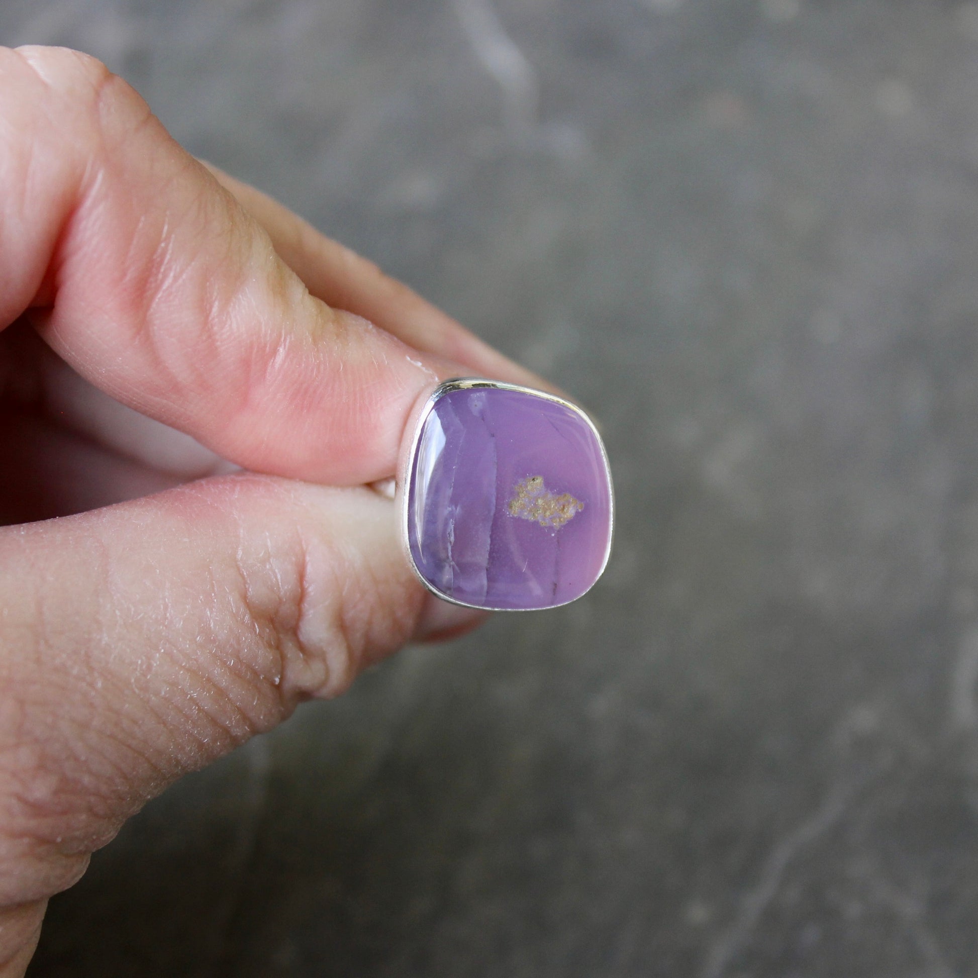 Hand holding a holley blue agate ring