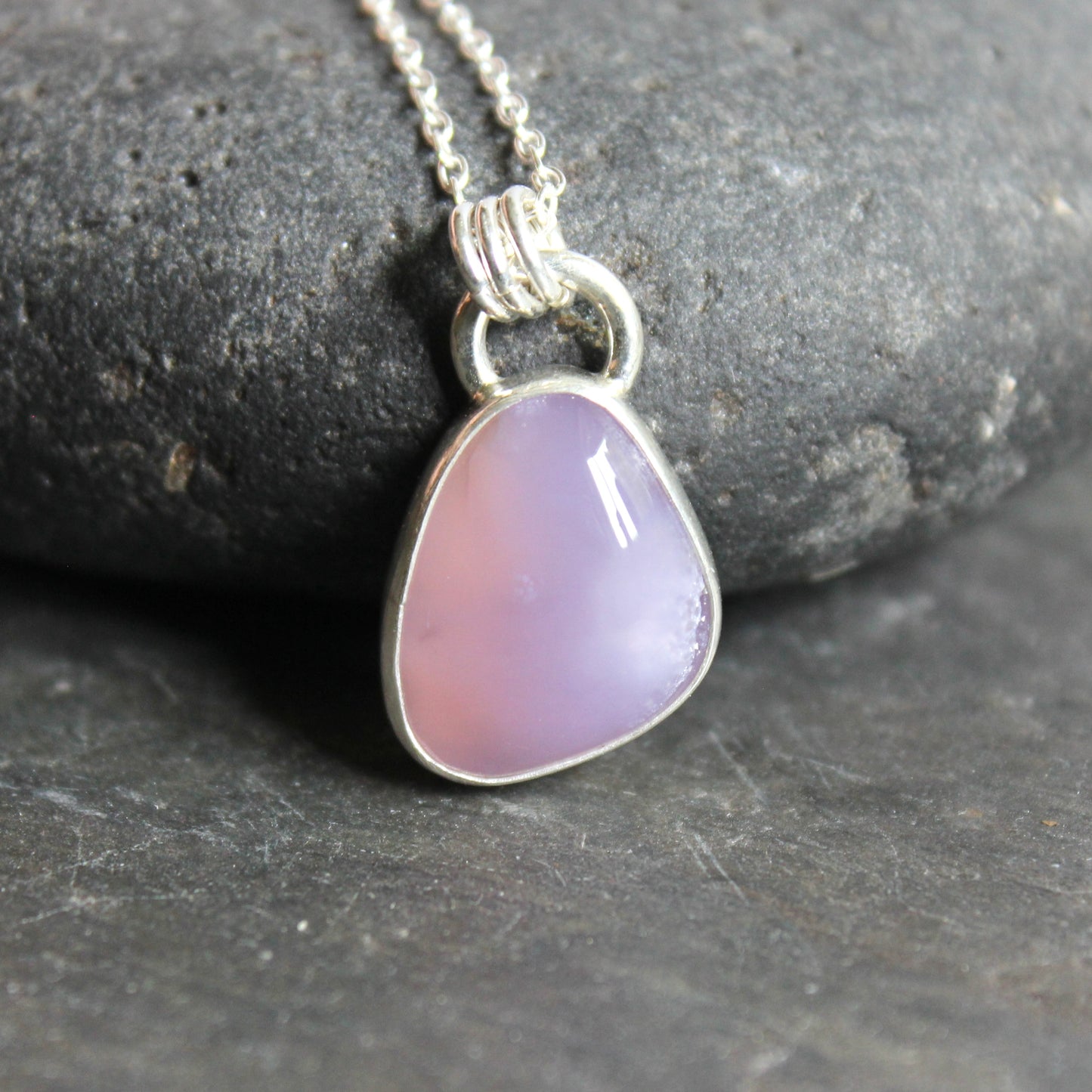 Necklace with a Holley Blue Agate teardrop pendant on a dark stone surface