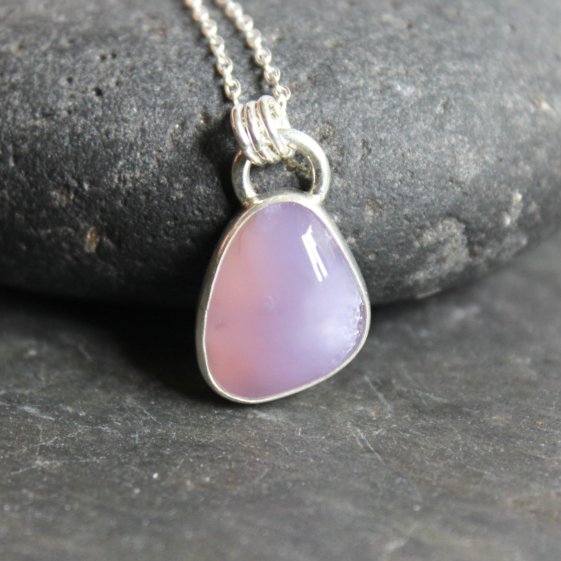 Necklace with a Holley Blue Agate teardrop pendant on a dark stone surface