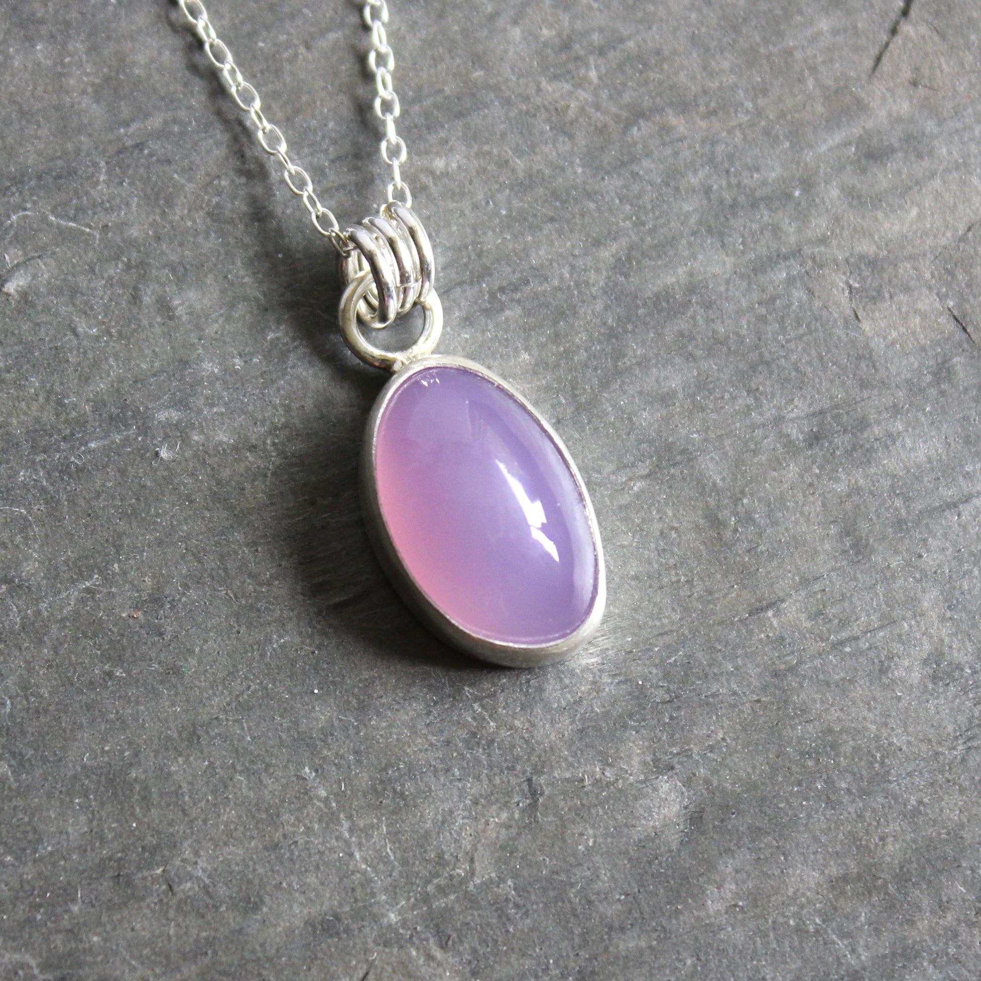 Necklace with a Holley Blue Agate pendant on a gray surface
