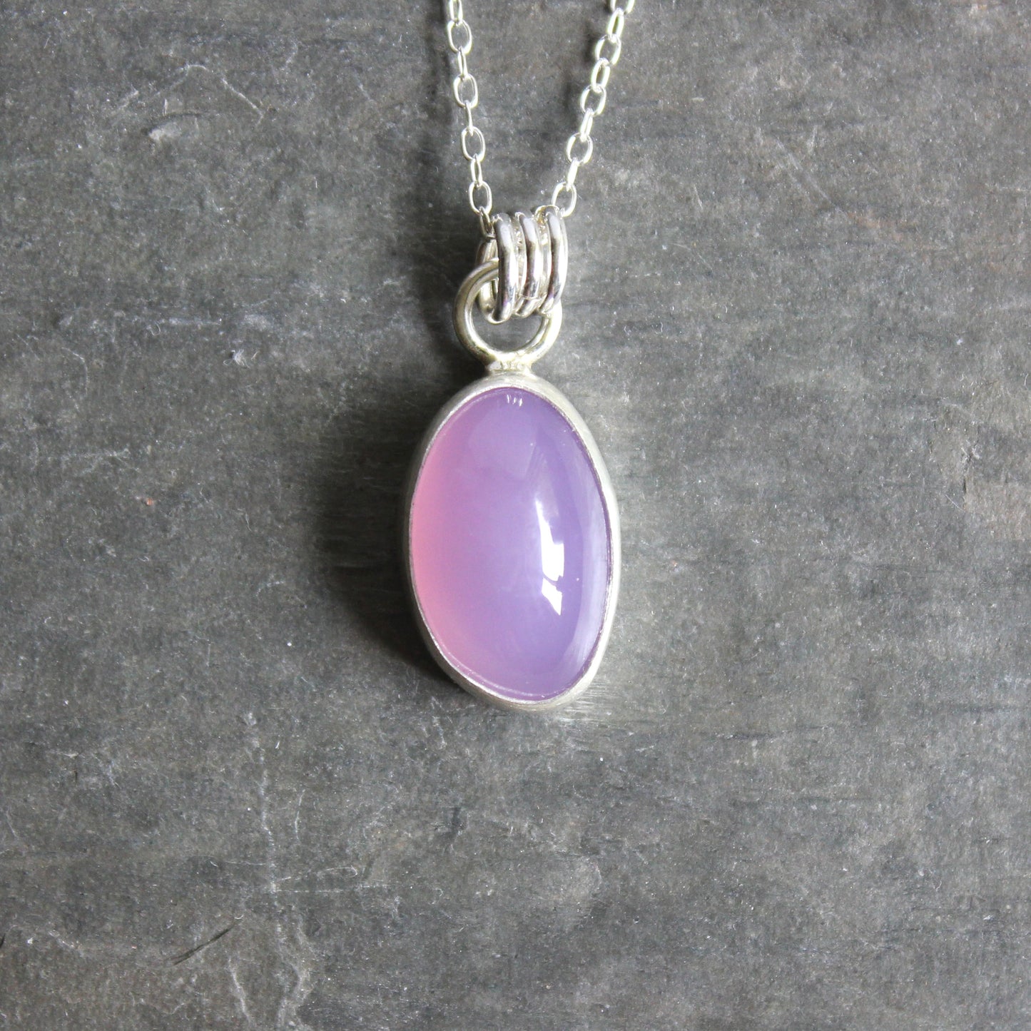 Necklace with a Holley Blue Agate pendant on a gray textured background