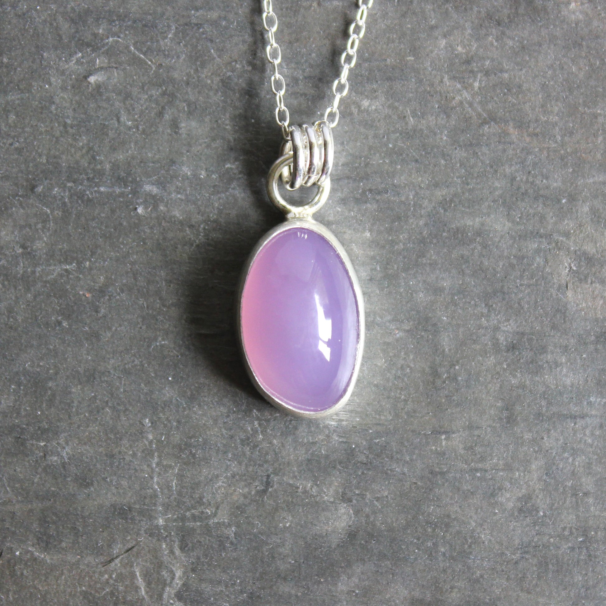 Necklace with a Holley Blue Agate pendant on a gray textured background
