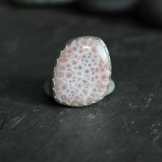 This is a large natrolite or pink larimar cabochon set in a fine & sterling silver scalloped bezel setting on a sturdy silver band.  Size 8
