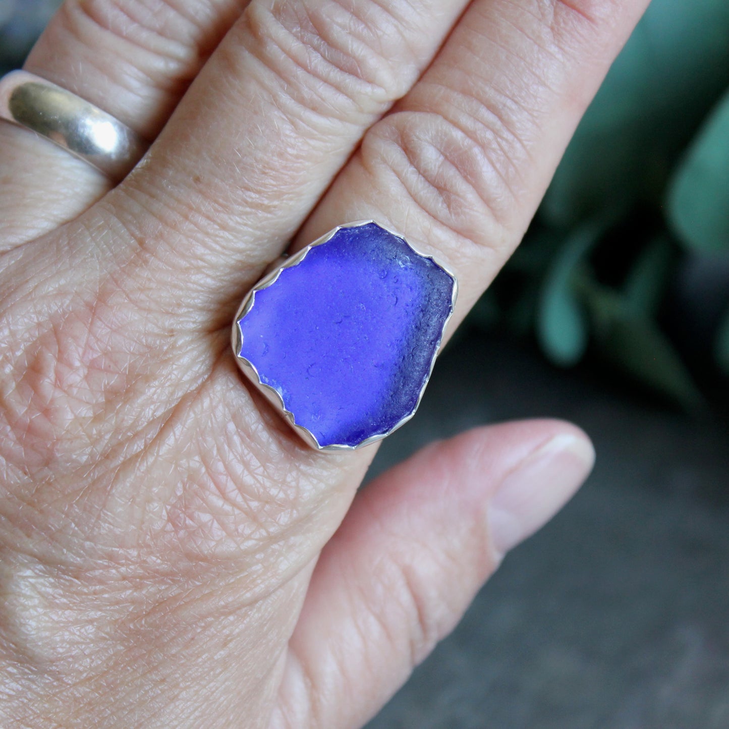 Hand wearing a blue sea glass ring