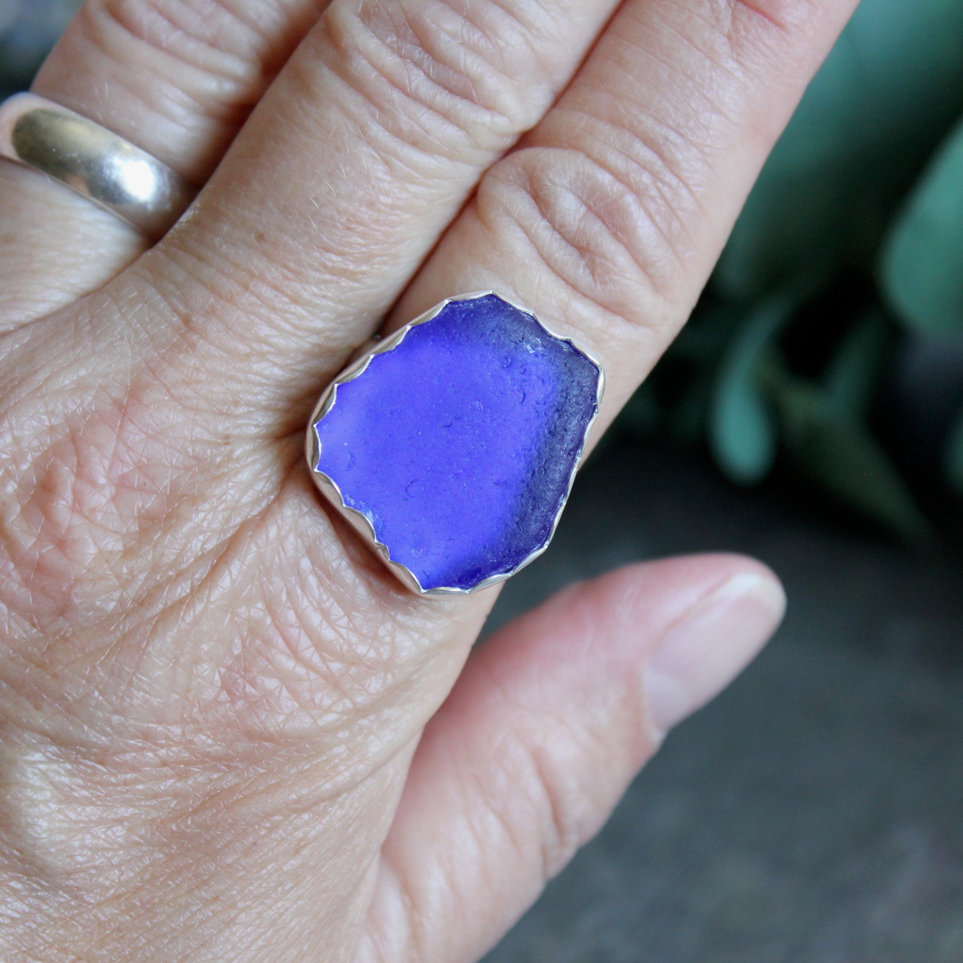Hand wearing a blue sea glass ring