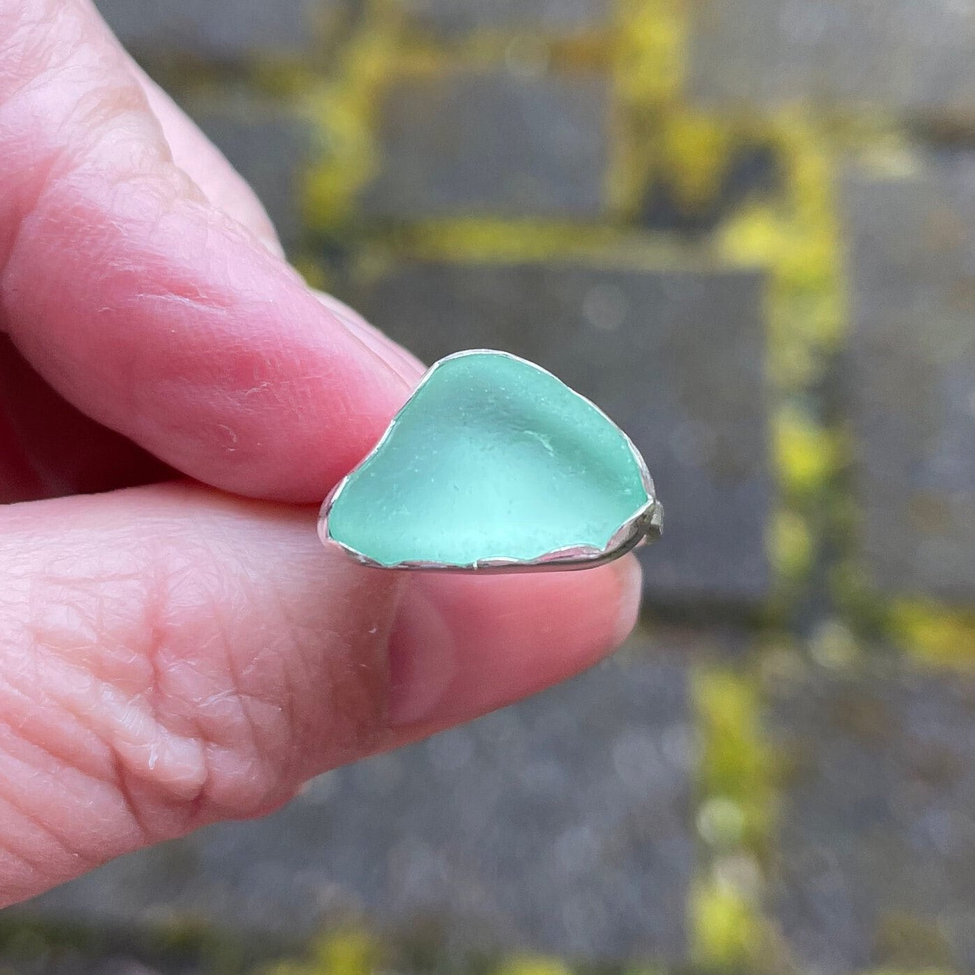 This ring has a sea foam green piece of sea glass set in a fine and sterling silver scalloped bezel setting on a sturdy silver band.  Handmade by Barb Macy in Corvallis, OR.  Size 4 1/4