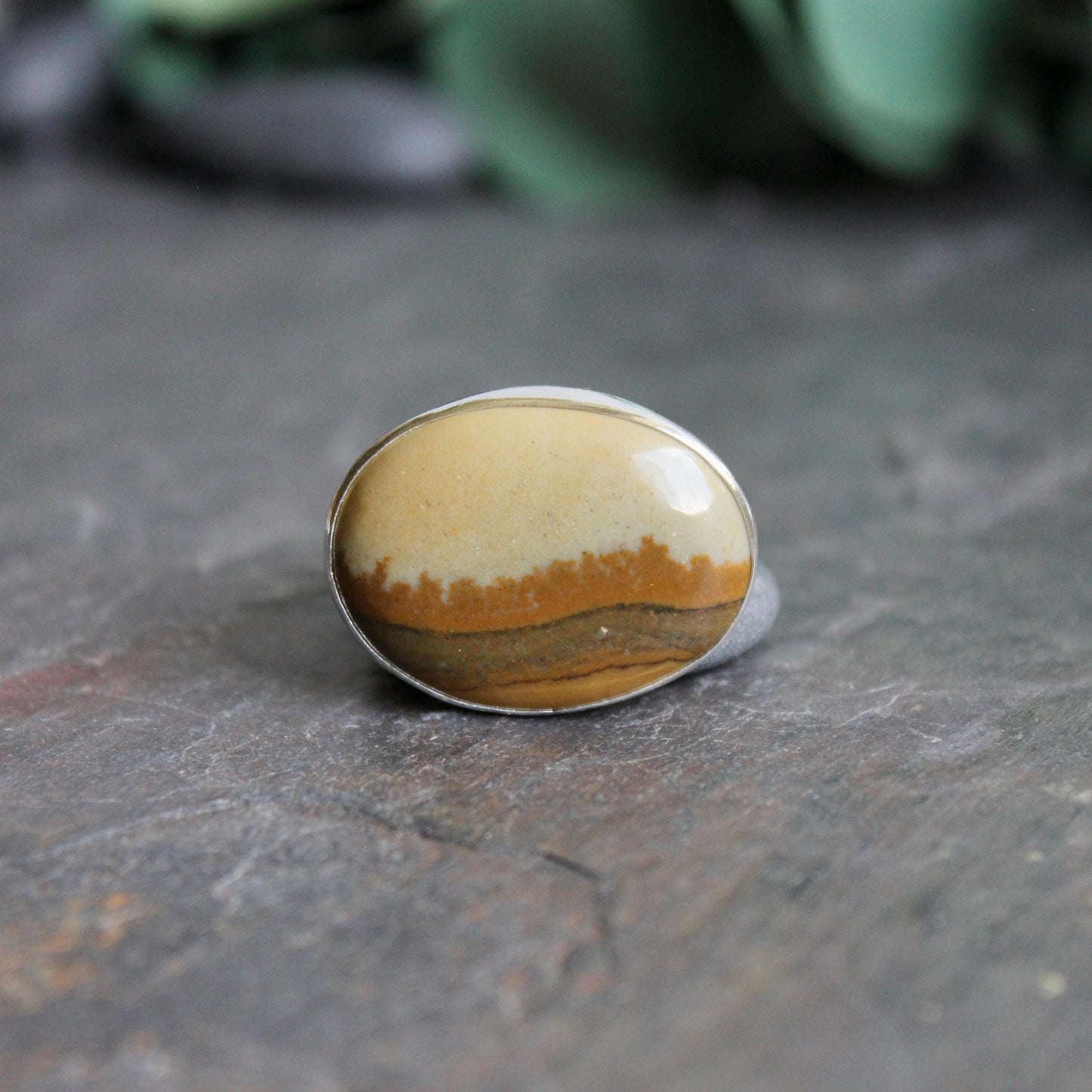 This ring has a large oval Owyhee picture jasper cabochon set in a fine and sterling silver bezel setting on a sturdy hammered band. Size 9 1/4