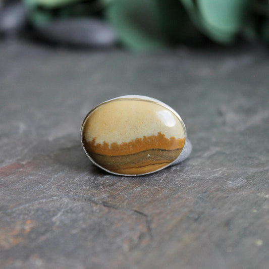 This ring has a large oval Owyhee picture jasper cabochon set in a fine and sterling silver bezel setting on a sturdy hammered band. Size 9 1/4