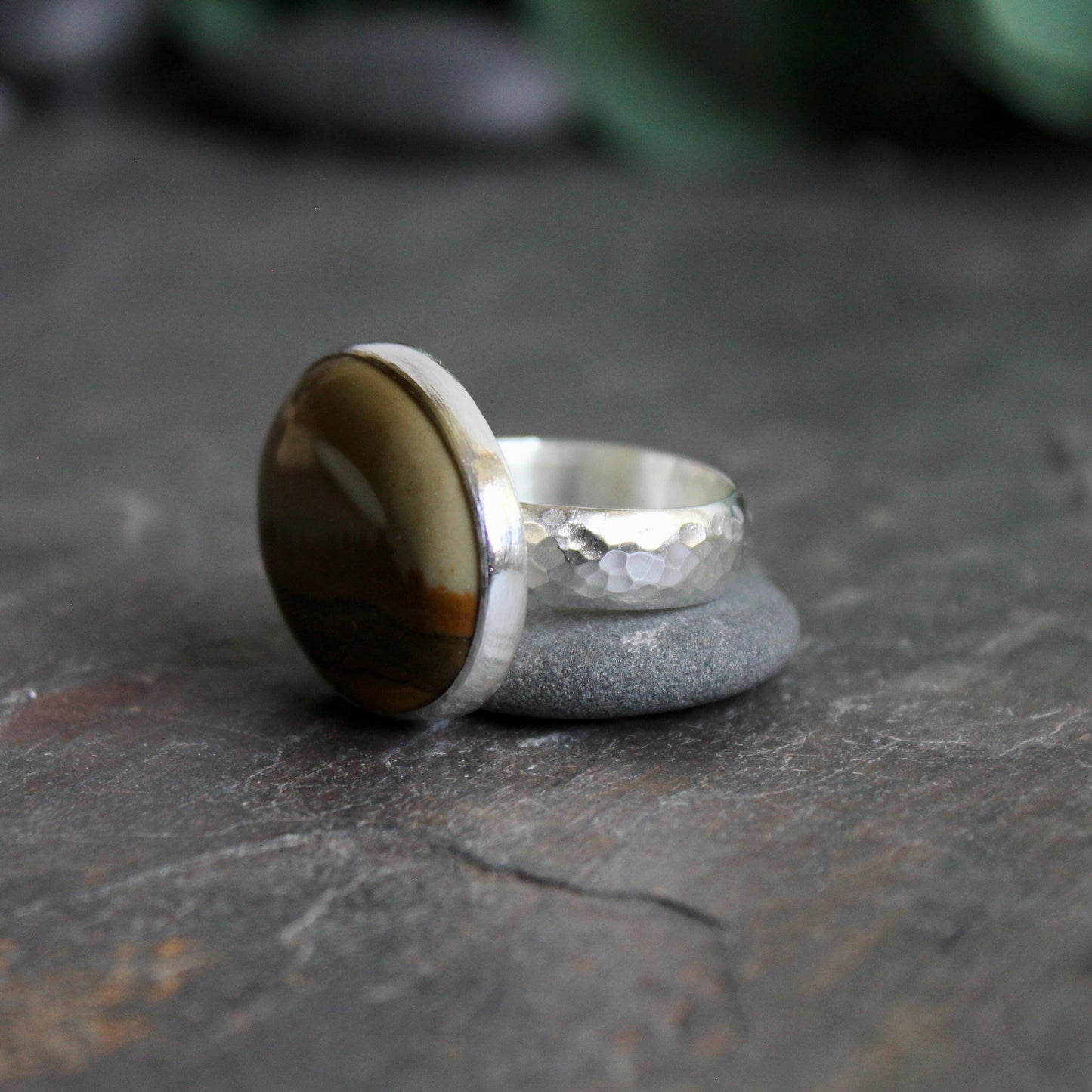 This ring has a large oval Owyhee picture jasper cabochon set in a fine and sterling silver bezel setting on a sturdy hammered band. Size 9 1/4