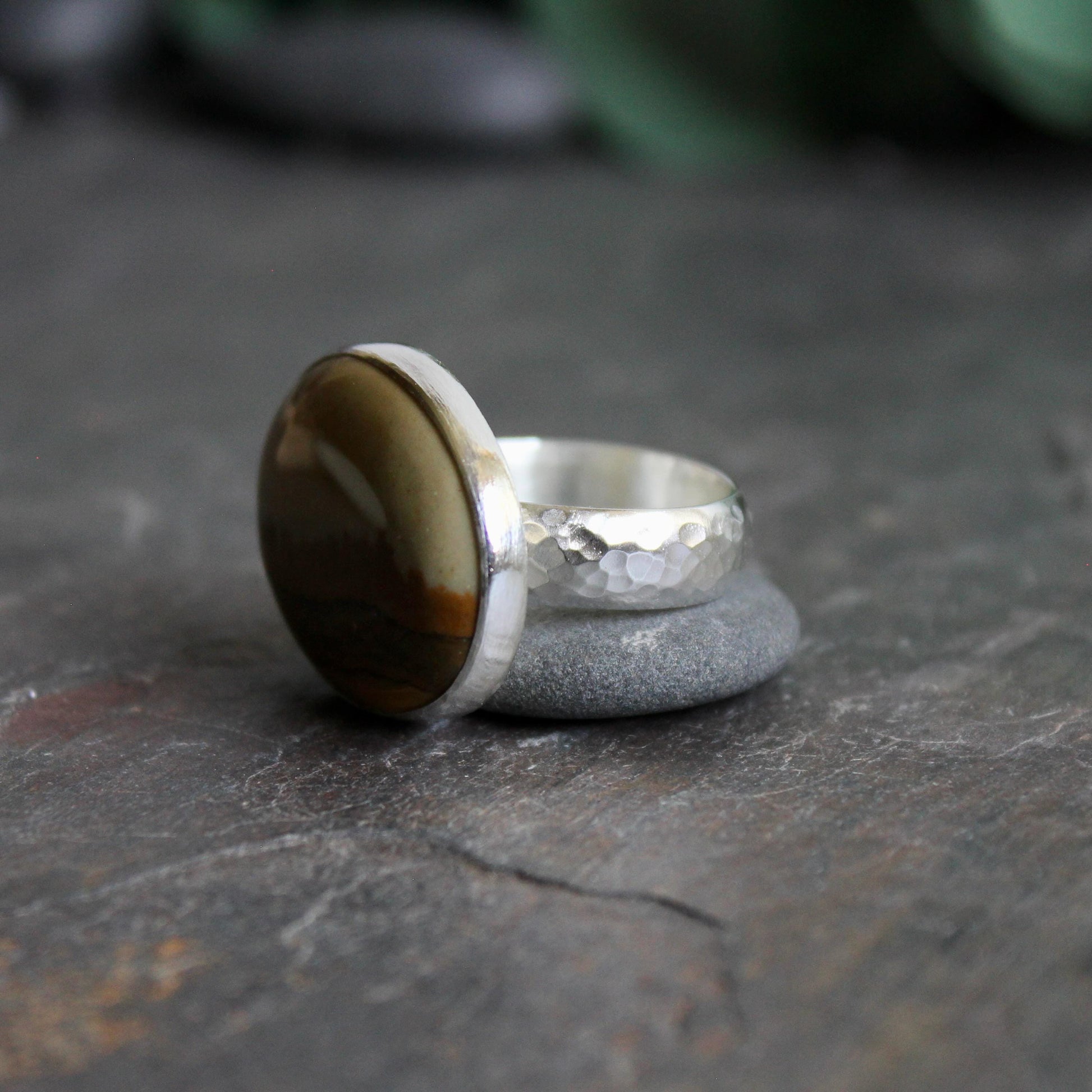This ring has a large oval Owyhee picture jasper cabochon set in a fine and sterling silver bezel setting on a sturdy hammered band. Size 9 1/4
