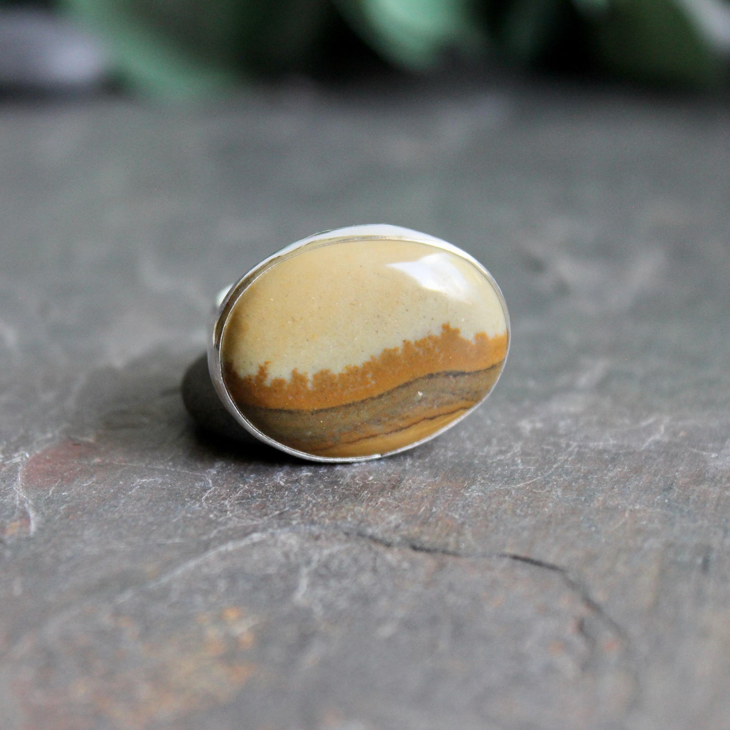 This ring has a large oval Owyhee picture jasper cabochon set in a fine and sterling silver bezel setting on a sturdy hammered band. Size 9 1/4
