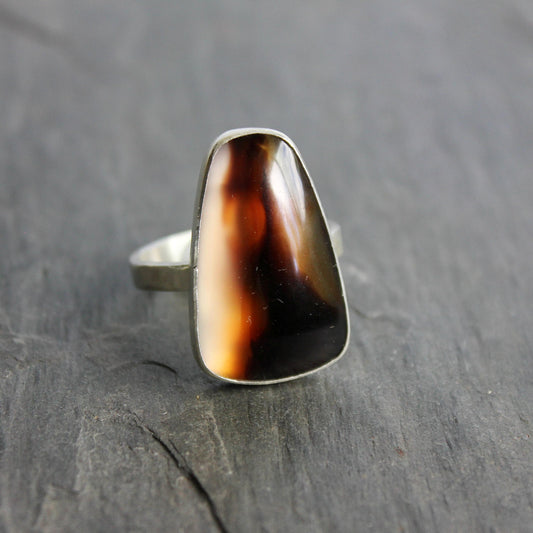 This ring has a large Montana agate cabochon set in a fine and sterling silver bezel setting on a sturdy hammered band. Handmade by Will Macy in Corvallis, OR.