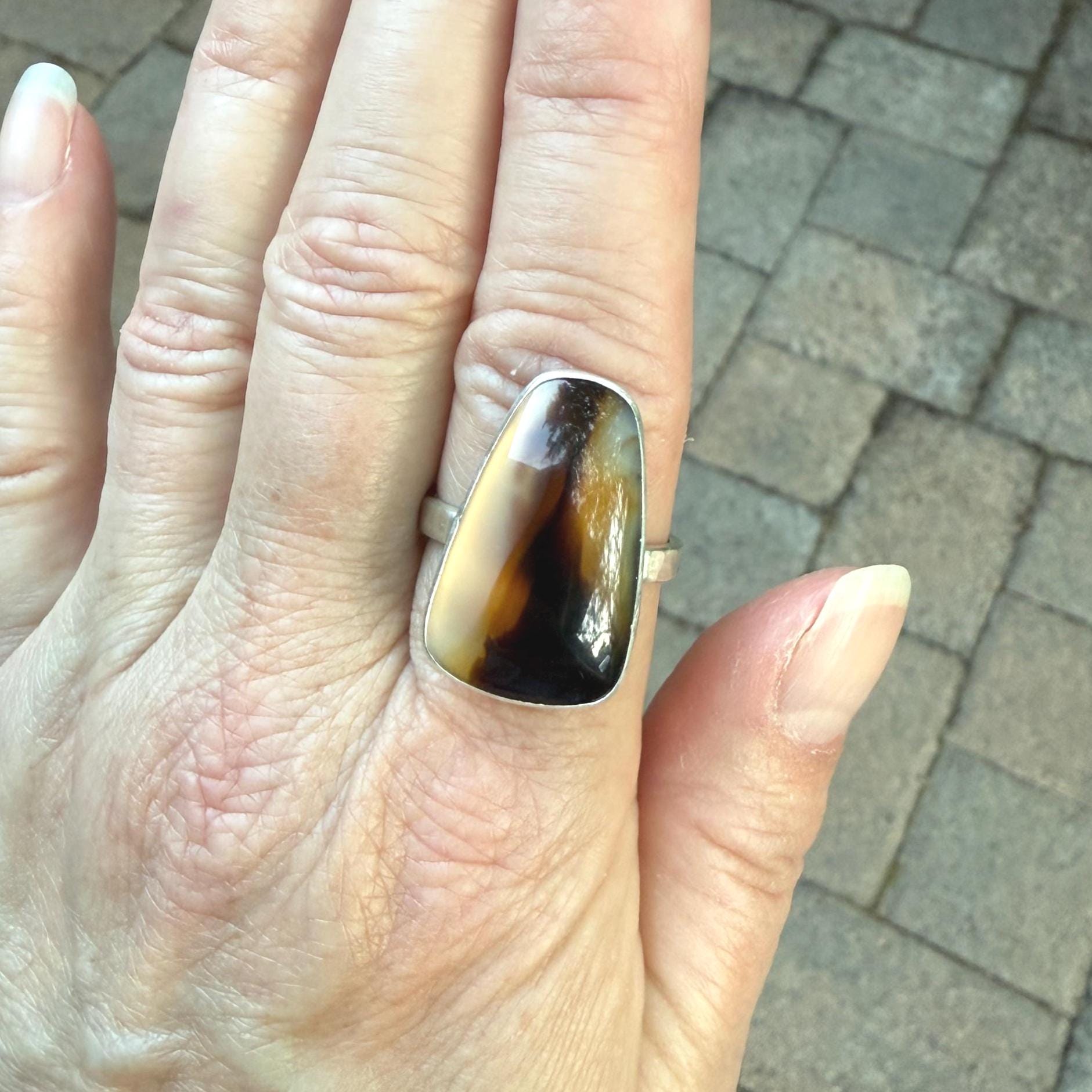 This ring has a large Montana agate cabochon set in a fine and sterling silver bezel setting on a sturdy hammered band. Handmade by Will Macy in Corvallis, OR.