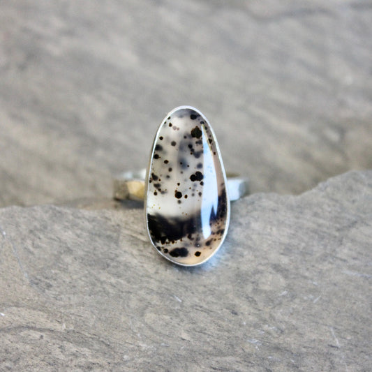 Silver ring with a Spotted Montana agate on a gray rock background