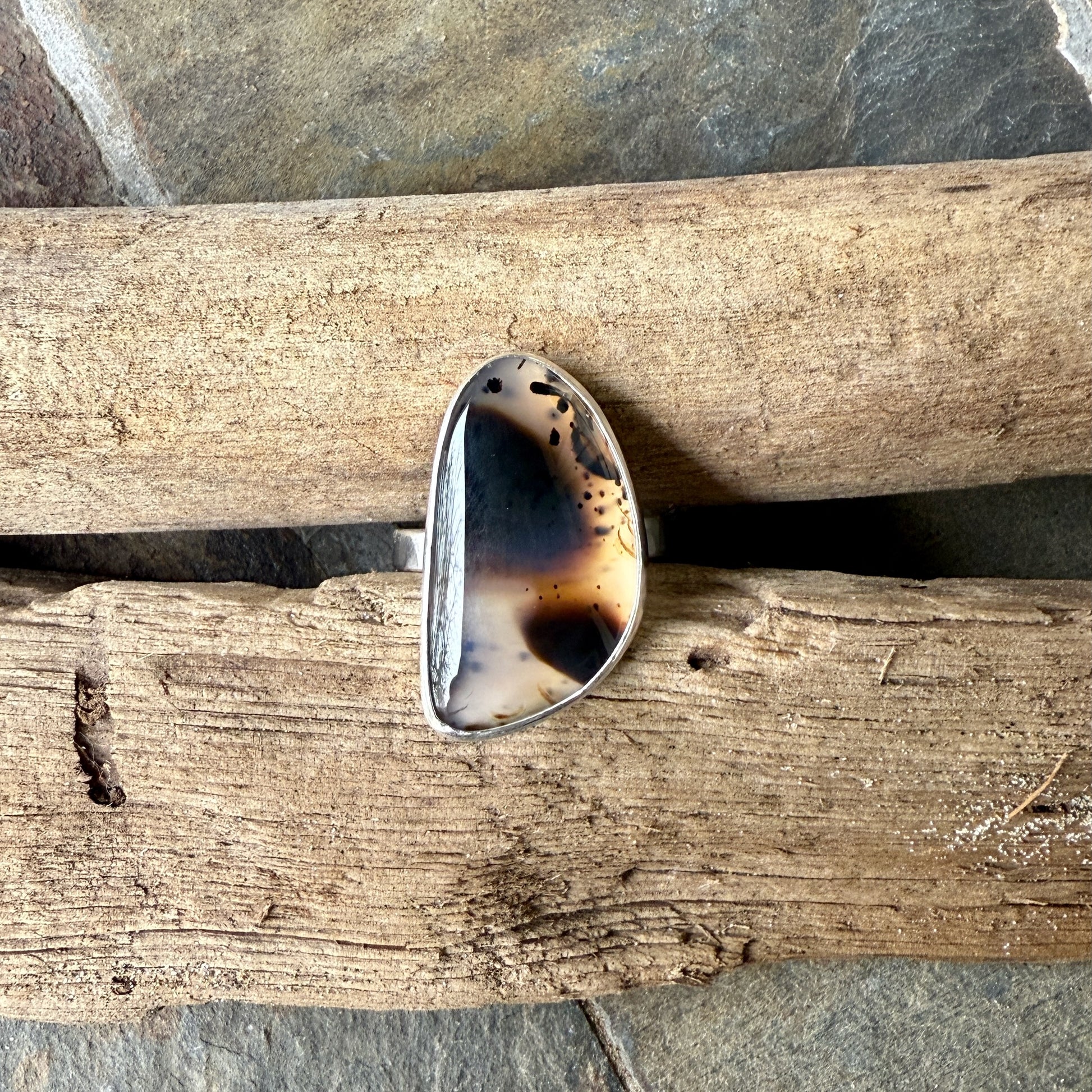 Ring with a unique montana agate design on a wooden surface